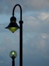 Two lampposts aligned against a cloudy blue sky Royalty Free Stock Photo