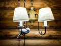 Two lamps with a dove on the background of the walls of a wooden house. Royalty Free Stock Photo