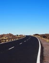 Two lane empty road curving to the horizon in desert landscape