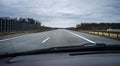 A two-lane highway seen from a moving car through the windshield.