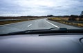 A two-lane highway seen from a moving car through the windshield.