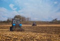 Two large blue tractor plow plowed land after harvesting the maize crop Royalty Free Stock Photo