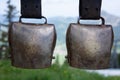 Two large brass-colored cowbells were hung up. In the background you can see a mountain landscape