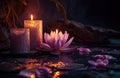 two large candles are beside a lotus flower on a dark background Royalty Free Stock Photo