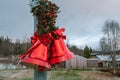 Two large Christmas red bells with red bow and pine leaves, street Christmas decoration, blurry background Royalty Free Stock Photo