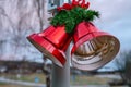 Two large Christmas red bells with red bow and pine leaves , street Christmas decoration, close up view, blurry background Royalty Free Stock Photo