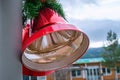 Two large Christmas red bells with red bow and pine leaves, street Christmas decoration, left side close up view, blurry Royalty Free Stock Photo