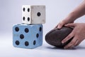 Two large dice and a child hand pick up football closeup on white background