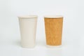 Two large disposable paper cups, white and brown.