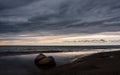 Granite stones close-up on the sea beach under the evening cloudy sky. Royalty Free Stock Photo