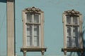 Two large gray old windows on the blue wall of a historic building Royalty Free Stock Photo