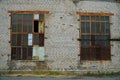 Two large old windows of an abandoned factory. Lattice on the broken windows