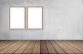 Two large picture frames mounted on a cement wall with wooden floors and space for the background Royalty Free Stock Photo