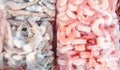 Two large plastic bags of frozen raw and cooked shrimp, on the counter of the fish market