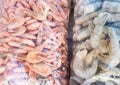 Two large plastic bags of frozen raw and cooked shrimp, on the counter of the fish market