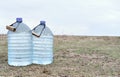 Two large plastic transparent carboys, capacity 5 gallons 19 liter, for water coolers with drinking water on a light background