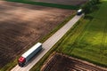 Two large semi-trucks on countryside road seen from drone pov, aerial shot of trucking and logistics concept