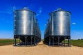 Two large silos are standing in a field Royalty Free Stock Photo