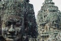Two large statues in the form of ancestral faces in the ruins of the Bayon temple in Ankgor Thom, Cambodia - UNESCO World Heritage Royalty Free Stock Photo