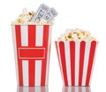 Two large striped boxes filled with popcorn, movie tickets on white. Royalty Free Stock Photo