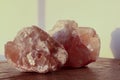 pink calcite crystals rest on a wooden surface, illuminated by warm light Royalty Free Stock Photo