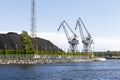 Two industrial cranes and coal piles Royalty Free Stock Photo
