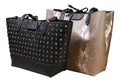 Two large women`s bags, one beige made of reptile skin, the other black, decorated with metal rivets