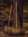 Two large wooden hammers leaning against a post