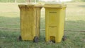Two large yellow trash cans for recycling or \