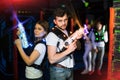 Two laser tag players standing back to back in bright beams Royalty Free Stock Photo