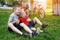 Two laughing boys having fun on the grass. Bicycles in the background