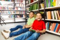 Two laughing boys sitting on the floor in library