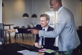 Two laughing businessmen pointing at a monitor in an office Royalty Free Stock Photo