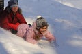 Two laughing little girls going down the snow slide Royalty Free Stock Photo