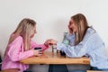 Two laughing mid age women friends sitting in cafe drinking coffee and chatting. Caucasian girls indoors Royalty Free Stock Photo