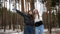 Two laughing teenage girls cheering and having fun because of snow in forest. People playing outdoors, winter holidays and Royalty Free Stock Photo