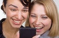 Two laughing women look at mobile phone Royalty Free Stock Photo