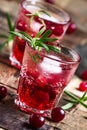 Two-layer cocktail with cranberry vodka, rosemary, soda and ice, vintage wooden background, selective focus Royalty Free Stock Photo