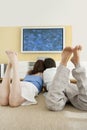 Two Laying Down on Floor Watching TV Royalty Free Stock Photo