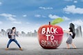 Two learners and apple with text of back to school