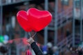 Two LED balloons in the form of scarlet burning hearts in the evening in girl`s hand. For a romantic background, for