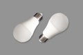 Two led bulb lights and energy-saving lamps on table on gray background Royalty Free Stock Photo