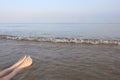 two legs with feet with nail polish while relaxing by the sea in Royalty Free Stock Photo