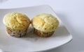 Two Lemon Ginger Muffins on White Plate and Table Royalty Free Stock Photo