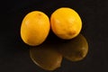 Two lemons on a black background