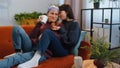 Two lesbian women family couple, girl friends drinking coffee, eating croissants and talking at home Royalty Free Stock Photo