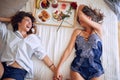 Lesbian woman laying in bed and holding hands and laughing Royalty Free Stock Photo