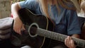 Two lgbt girls are sitting in the lining room on the sofa, playing guitar and singing songs, slow motion