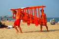Two lifeguards carrying the lifeguard tower