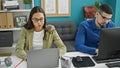 Two lifestyle professionals, man and woman coworkers, working together using computer and laptop in an elegant office interior Royalty Free Stock Photo